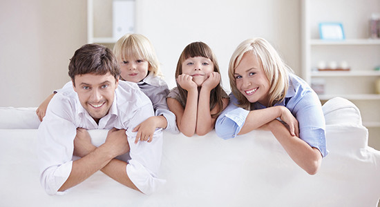 图像 of happy family look over the back of a couch for marketing
