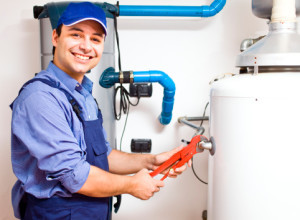 Image of a man with pipe wrench on water heater