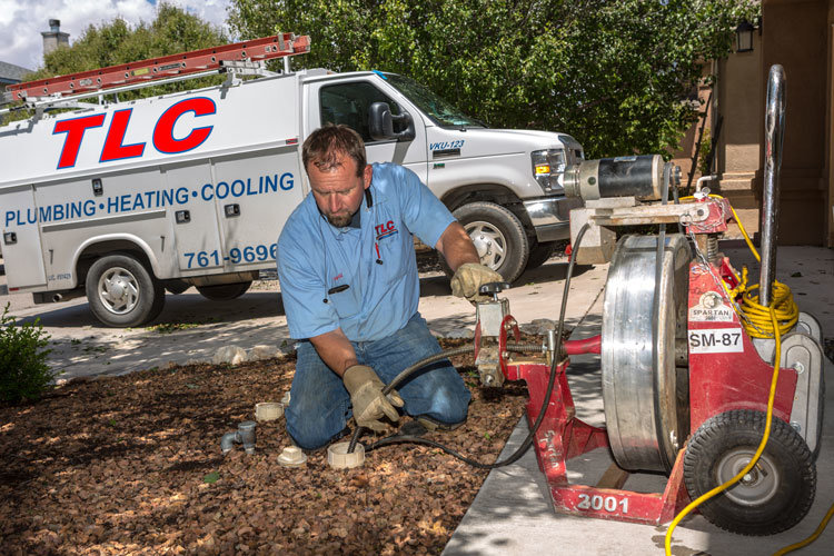 Image of a man using a drain cleaning tool