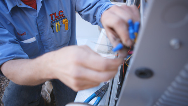 Image of a man splicing wires for furnace install