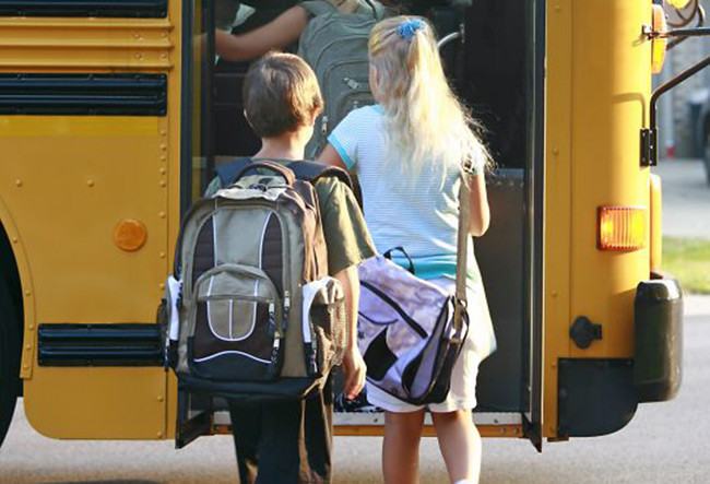 Image of kids getting on a bus