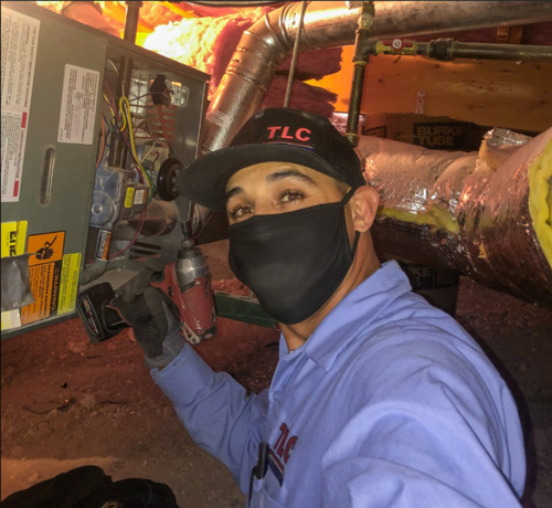 Image of a TLC repair man fixing a furnace
