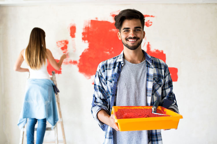 Image of a couple painting a wall in red