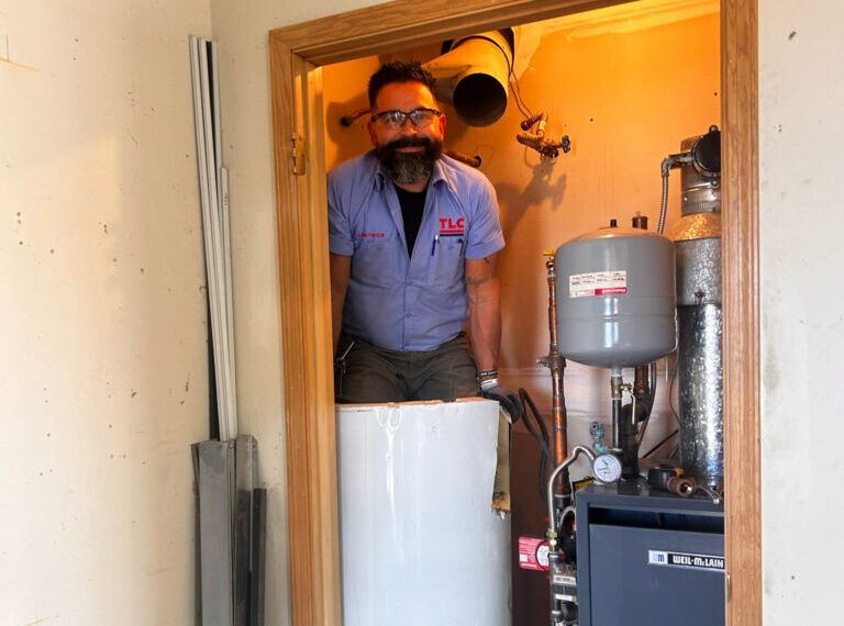Image of a water heater and professional installer Albuquerque
